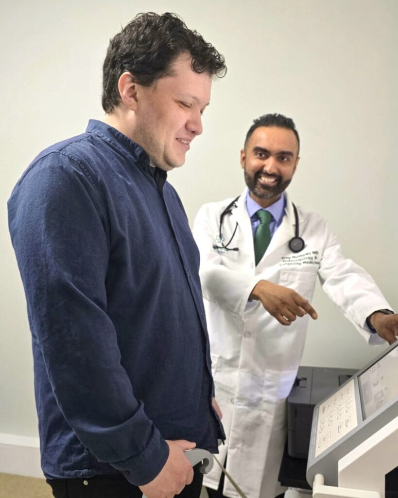 Dr. Mathews reviews diagnostic data with a patient during a wellness assessment at Sequoia Medical 360, guiding them through advanced body composition analysis.